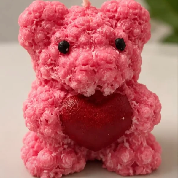 Pink rose-textured teddy bear soy candle holding a glittery red heart