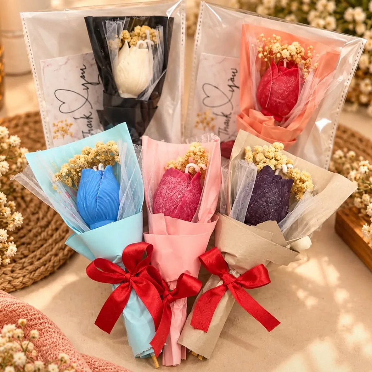 Tulip soy candles in white, peach, blue, pink and purple, each wrapped as a mini bouquet with a red bow